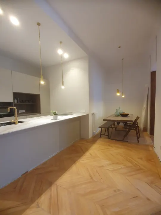 Cocina abierta al comedor, con parquet en espiga