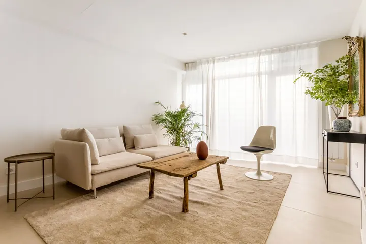 Salón con sofá beige y cortinas de lino